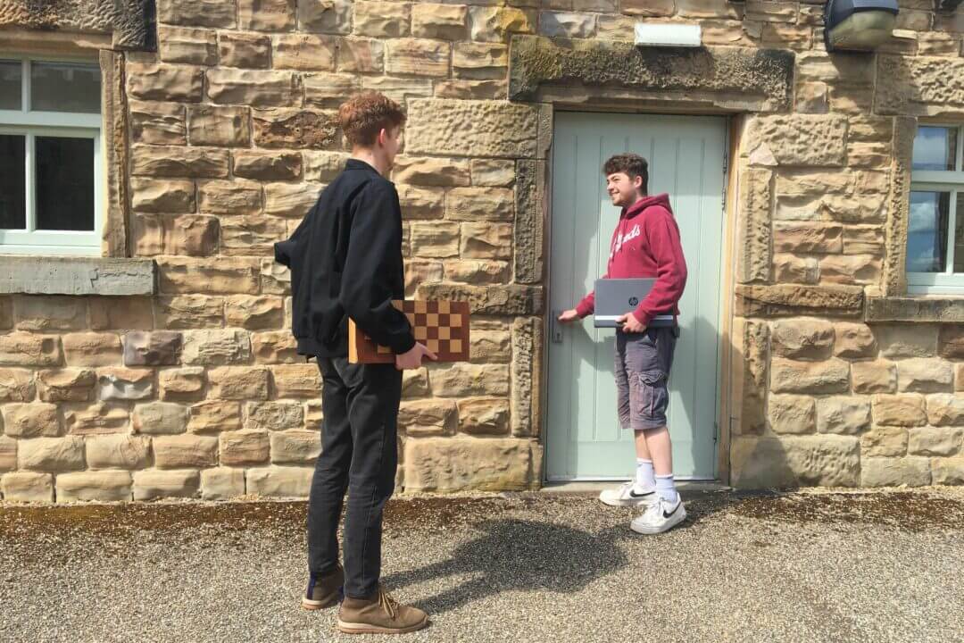 two male students outside a building