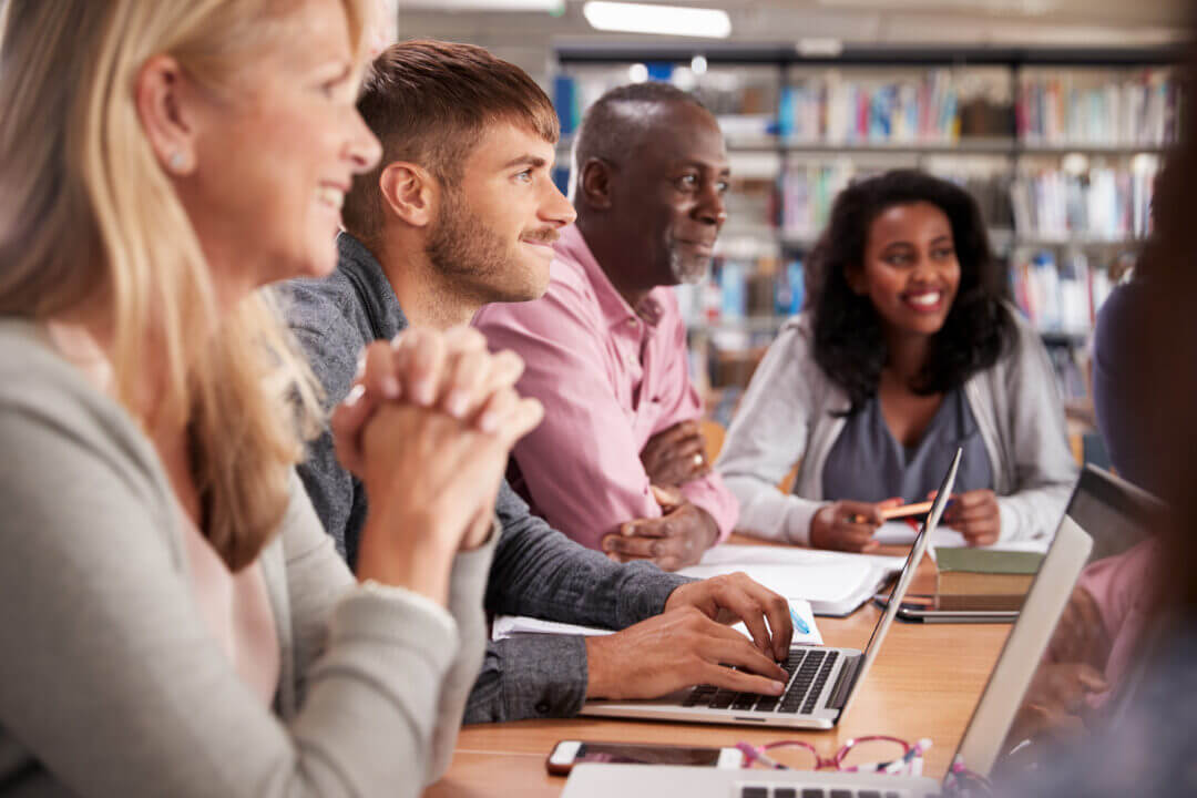 Group of mature students in classroom setting, smiling