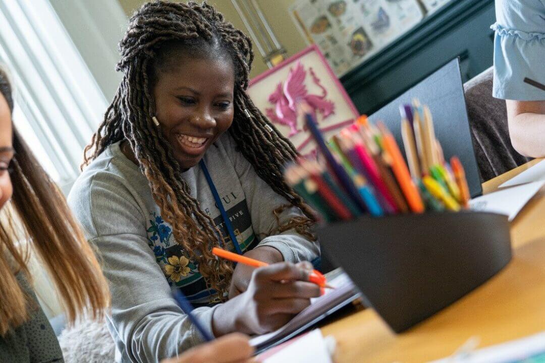 student smiling while writing