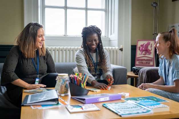 students sitting around a table smiling