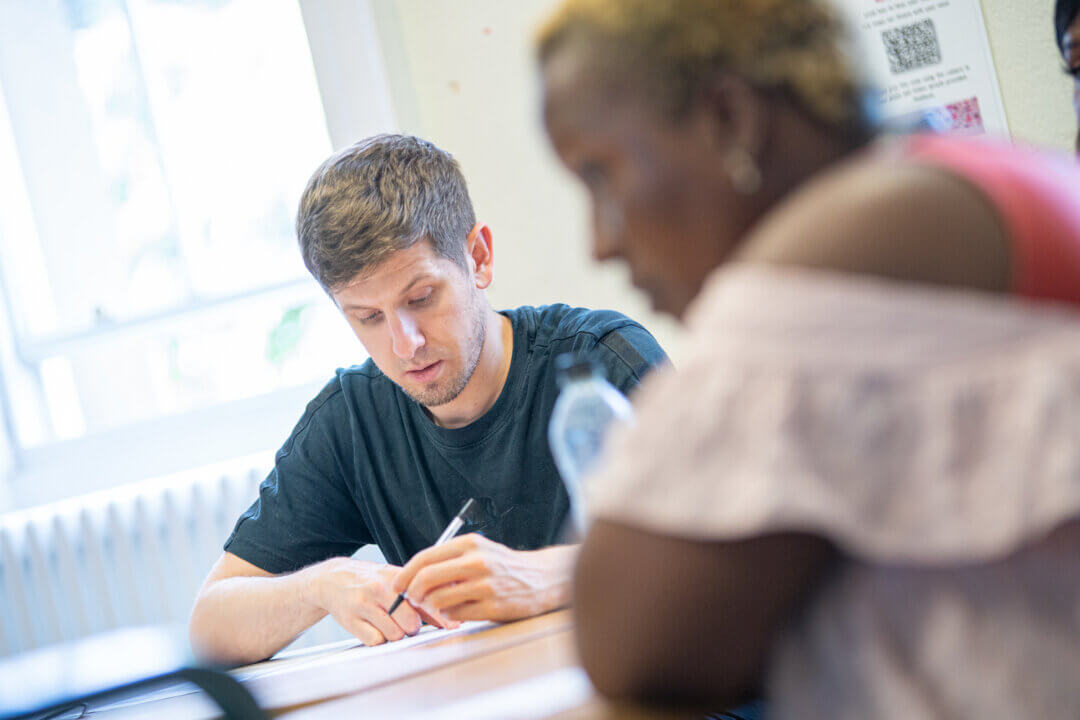 Male Student working with female student out of focus in the foreground